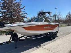 Slide: The Image of 2024 MasterCraft X22 boat on trailer, displayed outdoors with a "Current" flag nearby. - 5