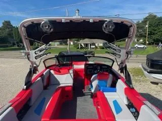 Slide: The Image of 2023 MasterCraft NXT 22 boat interior with red and gray seating, open canopy. - 11