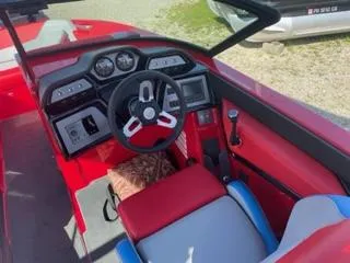 Slide: The Image of 2023 MasterCraft NXT 22 boat interior with red and gray seating and modern dashboard. - 7
