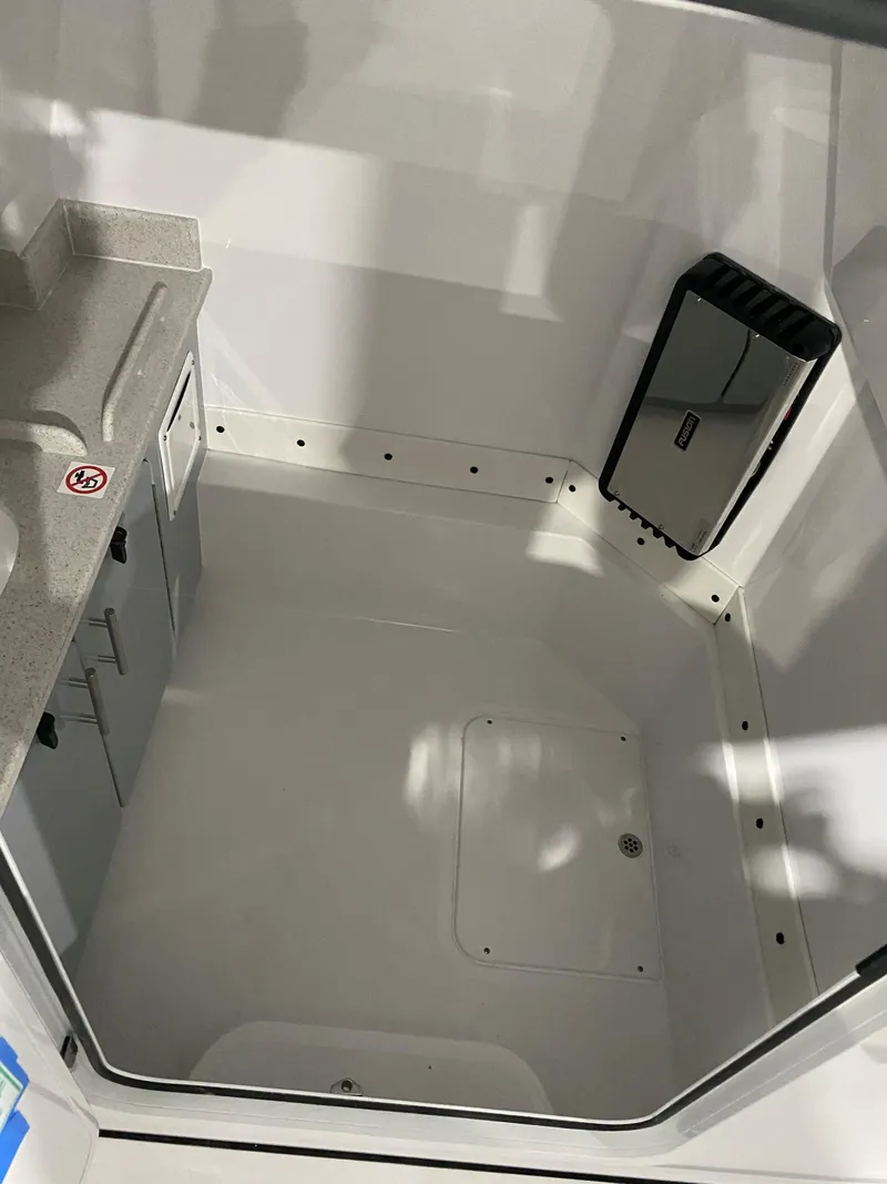 Slide: The Image of 2025 Stingray 253CC boat interior with storage and mirror. - 11