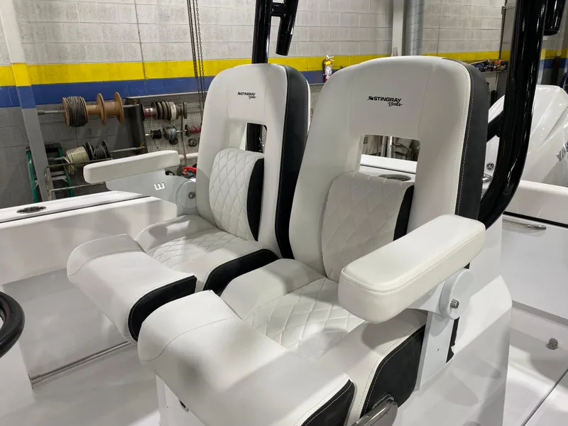 Slide: The Image of 2025 Stingray 253CC boat seats, white and black upholstery, in a workshop setting. - 12