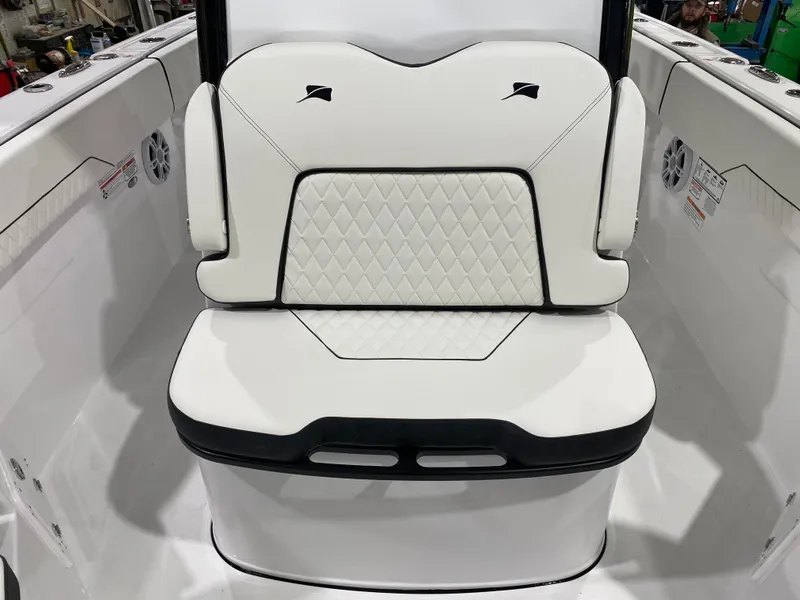 Slide: The Image of 2025 Stingray 253CC boat interior with white cushioned seating and diamond pattern design. - 14