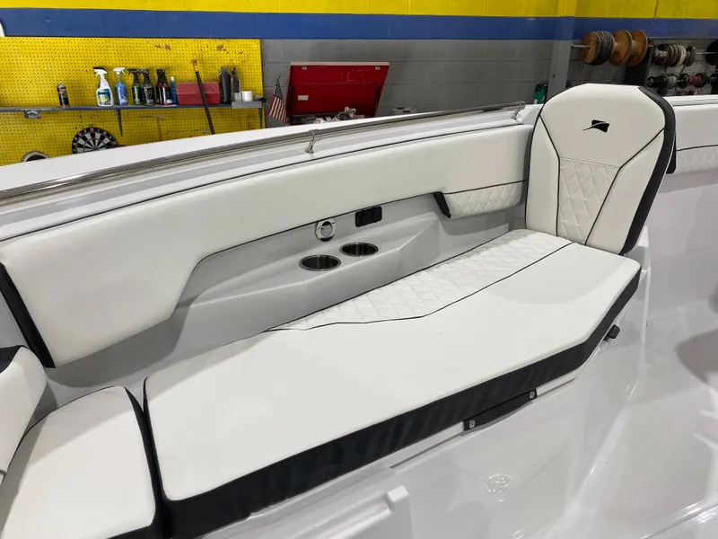 Slide: The Image of 2025 Stingray 253CC boat interior with white cushioned seating and cup holders. - 15