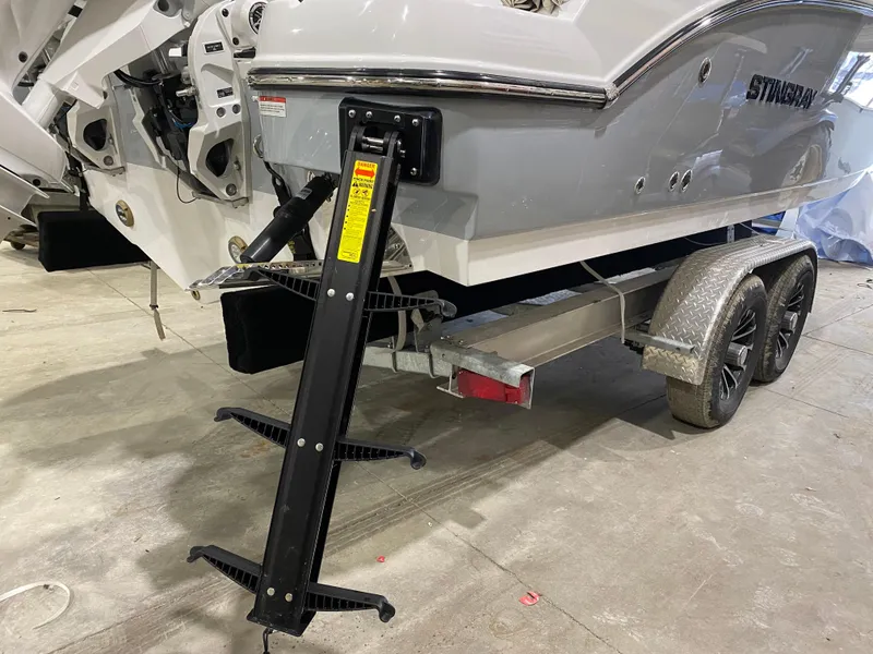 Slide: The Image of 2025 Stingray 253CC boat on trailer with ladder attachment in a garage. - 3