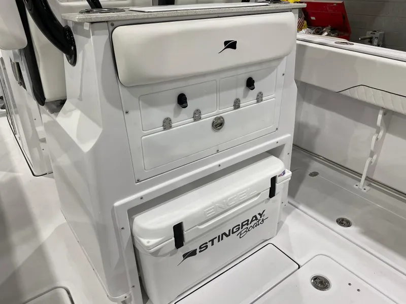 Slide: The Image of 2025 Stingray 253CC boat interior with storage compartments and cooler. - 8