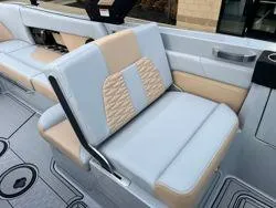 Slide: The Image of 2024 MasterCraft X26 boat interior with beige and gray seating. - 9