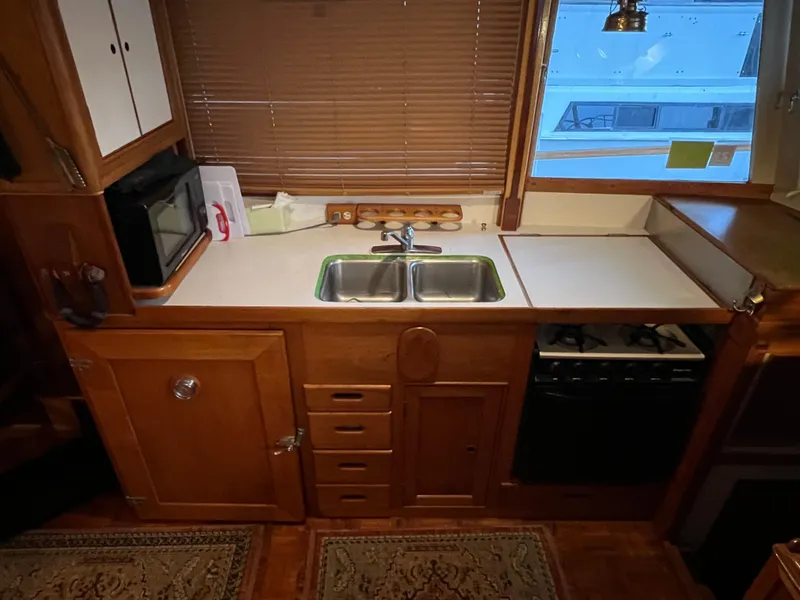 Slide: The Image of 1972 Grand Banks 42 Classic kitchen with wooden cabinetry, double sink, and stove. - 11