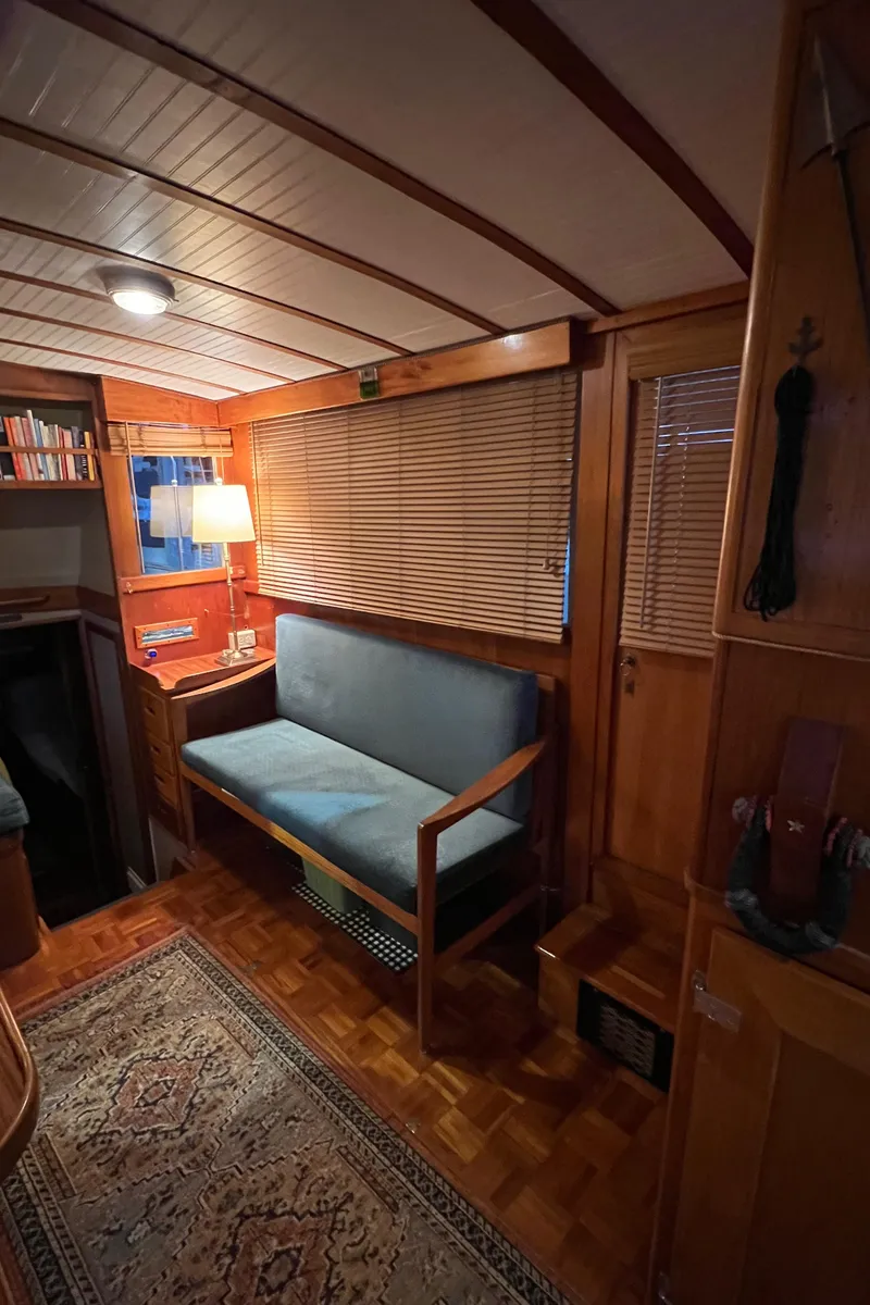 Slide: The Image of Cozy interior of a 1972 Grand Banks 42 Classic yacht with wooden furnishings and a blue sofa. - 15