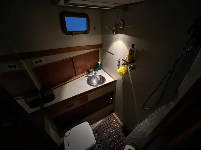 Slide: The Image of 1972 Grand Banks 42 Classic yacht bathroom with sink, shower, and wooden cabinetry. - 24