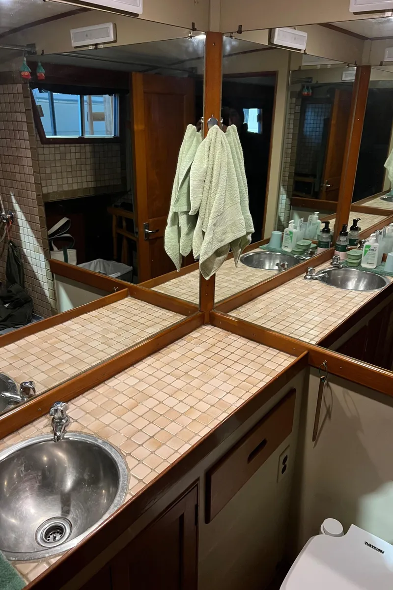 Slide: The Image of 1972 Grand Banks 42 Classic yacht bathroom with dual sinks, mirrors, and tiled countertop. - 26