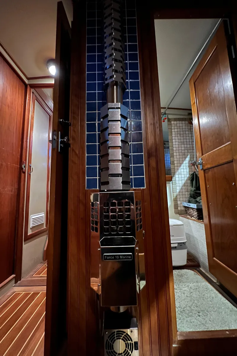 Slide: The Image of Interior of a 1972 Grand Banks 42 Classic yacht, featuring wood paneling and a compact bathroom. - 27
