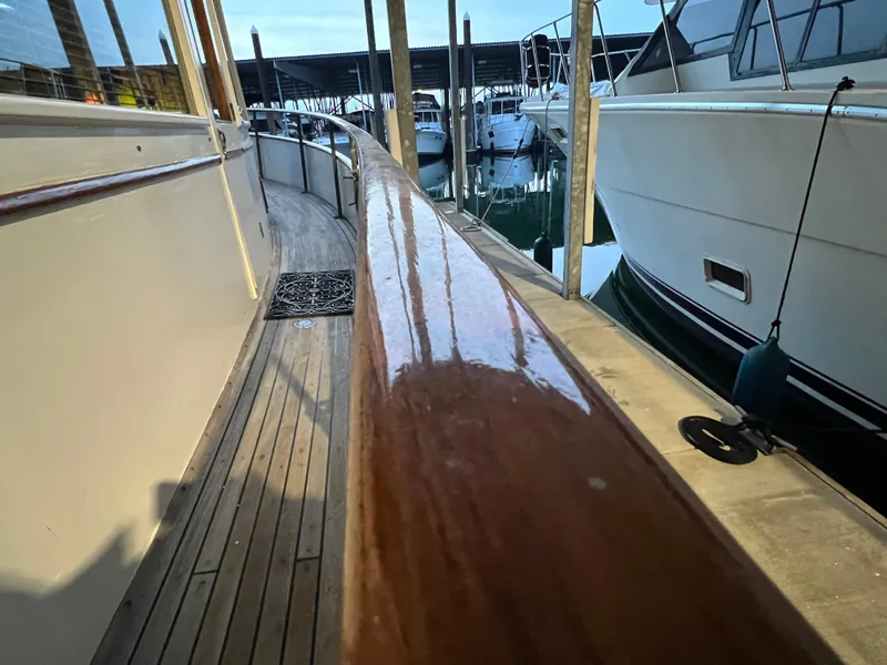 Slide: The Image of 1972 Grand Banks 42 Classic yacht docked, showcasing polished wooden rail and deck. - 6