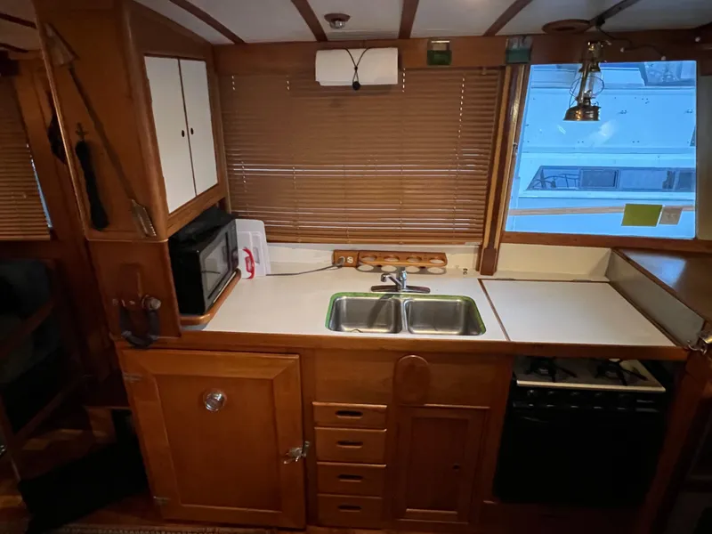 Slide: The Image of 1972 Grand Banks 42 Classic yacht kitchen with wooden cabinetry, double sink, and appliances. - 9