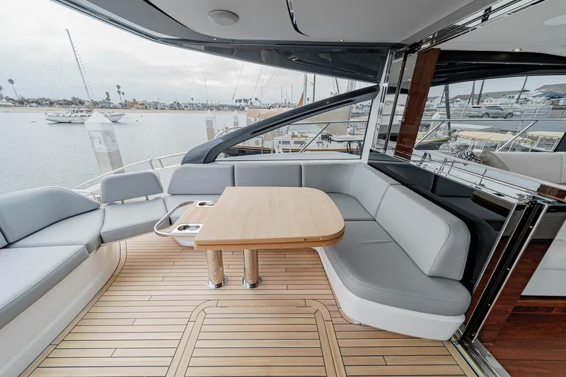 Slide: The Image of Luxurious 2025 Princess V55 yacht interior with elegant seating and wooden table. - 11