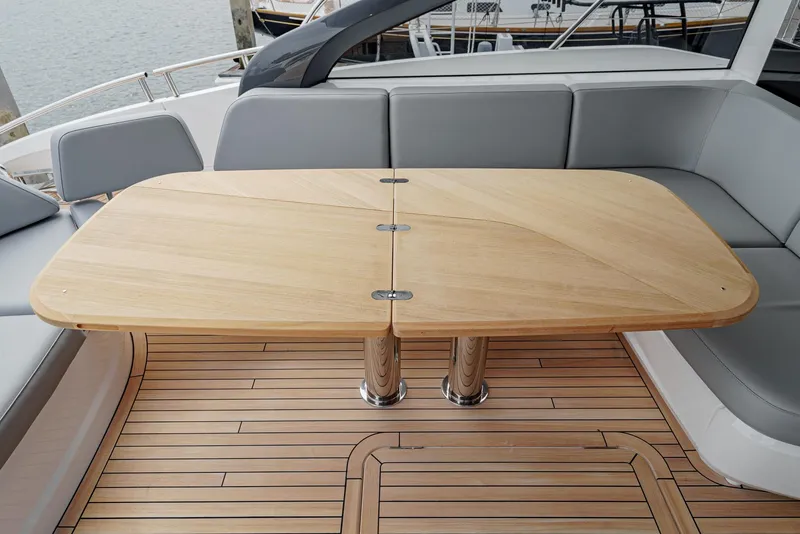 Slide: The Image of Luxury yacht Princess V55 2025 with elegant wooden table and sleek seating. - 12