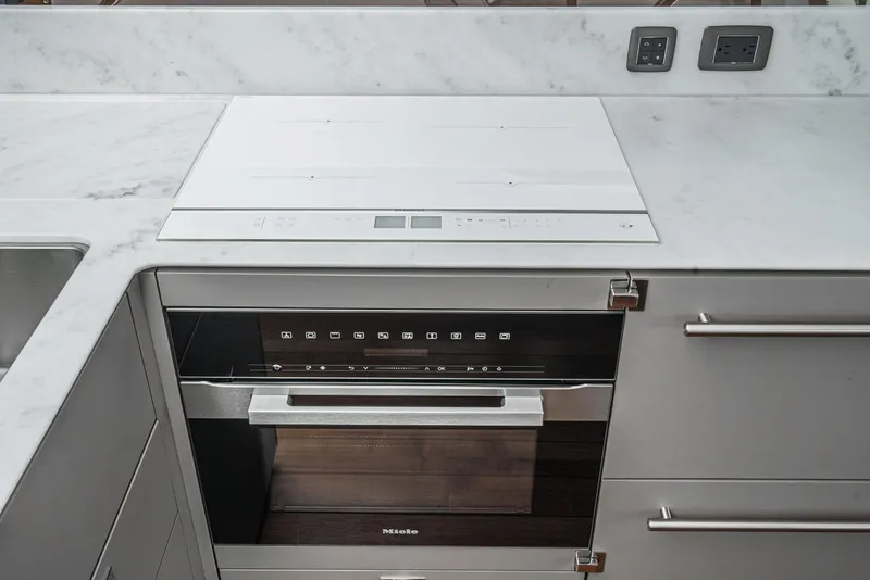 Slide: The Image of Modern kitchen with sleek appliances, marble countertop, and integrated oven. - 23