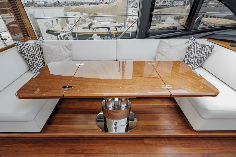 Slide: The Image of Luxurious interior of 2025 Princess V55 yacht with elegant wooden table and white seating. - 26