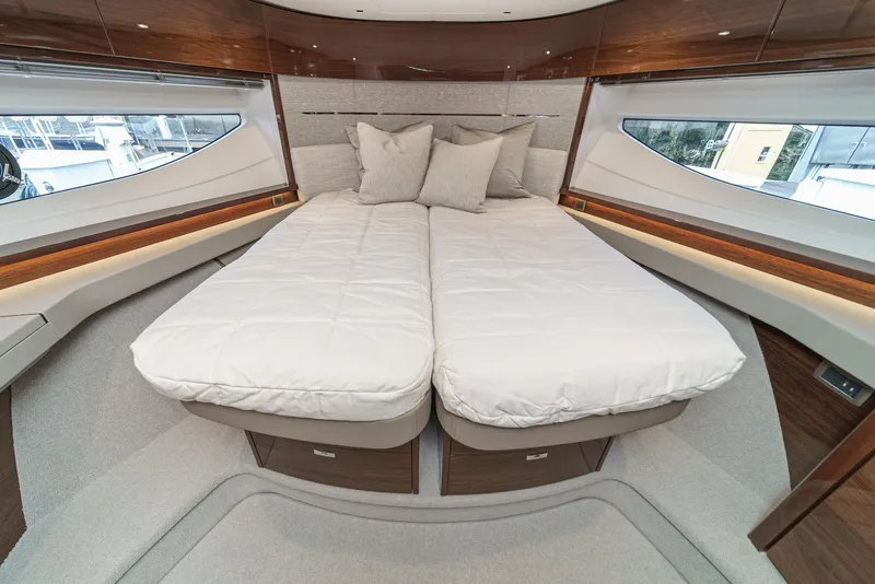 Slide: The Image of Luxurious 2025 Princess V55 yacht bedroom with twin beds and elegant wood accents. - 42