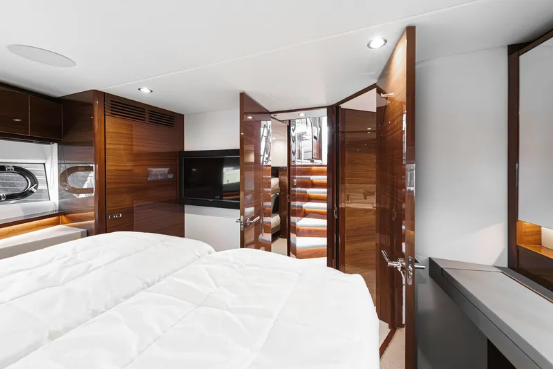 Slide: The Image of Luxurious interior of 2025 Princess V55 yacht with modern wood finishes and cozy bedding. - 43