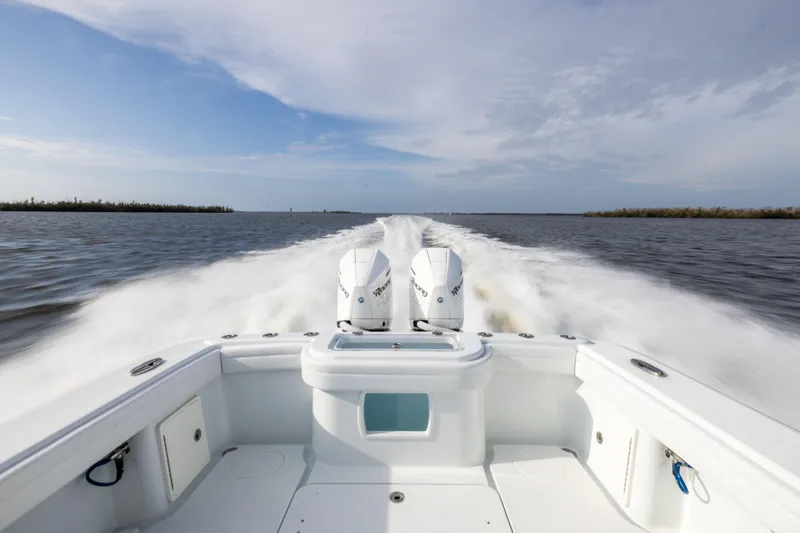 Slide: The Image of 2021 Yellowfin 36 Offshore boat speeding on open water, twin engines visible. - 19