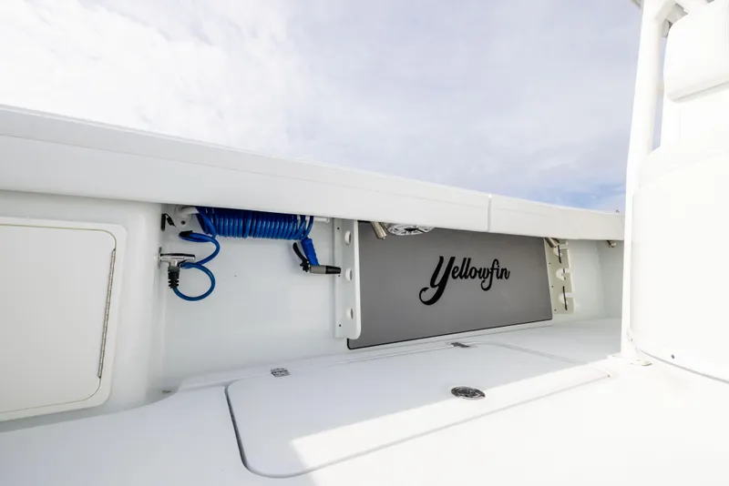Slide: The Image of 2021 Yellowfin 36 Offshore boat interior with storage compartment and coiled hose. - 25