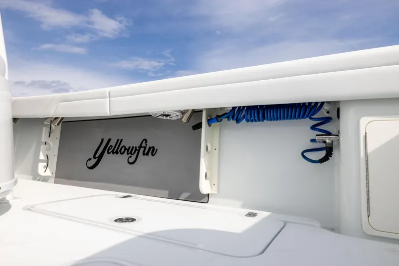 Slide: The Image of 2021 Yellowfin 36 Offshore boat interior with storage compartment and coiled hose. - 26