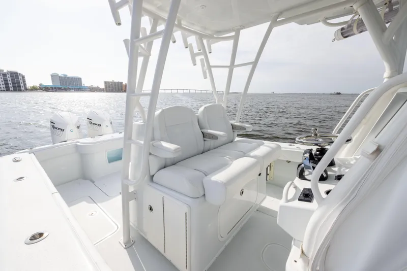 Slide: The Image of 2021 Yellowfin 36 Offshore boat interior with white seating, overlooking calm waters. - 34