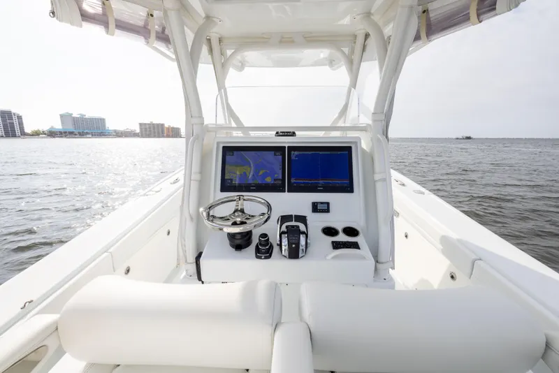 Slide: The Image of 2021 Yellowfin 36 Offshore boat dashboard with navigation screens on open water. - 35