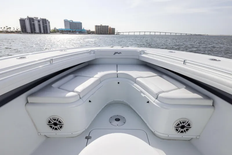 Slide: The Image of 2021 Yellowfin 36 Offshore boat interior with cushioned seating, ocean view, and city skyline. - 48
