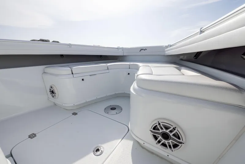 Slide: The Image of 2021 Yellowfin 36 Offshore boat interior with white cushioned seating and speakers. - 49