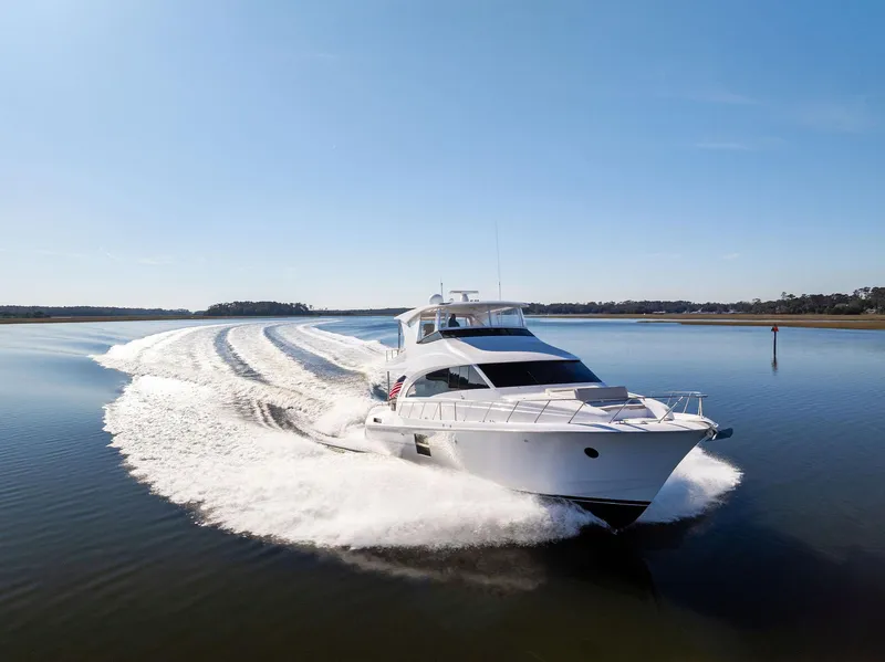 The Image of 2016 Hatteras M60 yacht cruising on calm waters under clear blue skies. - 0