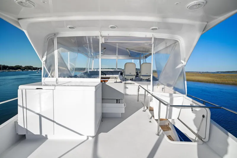 Slide: The Image of Hatteras M60 yacht view, 2016 model, overlooking serene water and distant shoreline. - 11