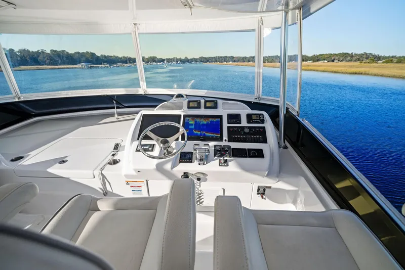 Slide: The Image of Luxurious 2016 Hatteras M60 yacht interior with modern helm and seating, overlooking serene waters. - 15