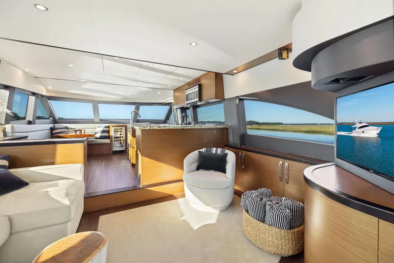 Slide: The Image of Luxurious 2016 Hatteras M60 yacht interior with elegant seating and waterfront view. - 18
