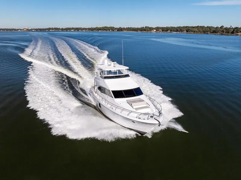 Slide: The Image of 2016 Hatteras M60 yacht cruising on calm waters, rear view. - 3