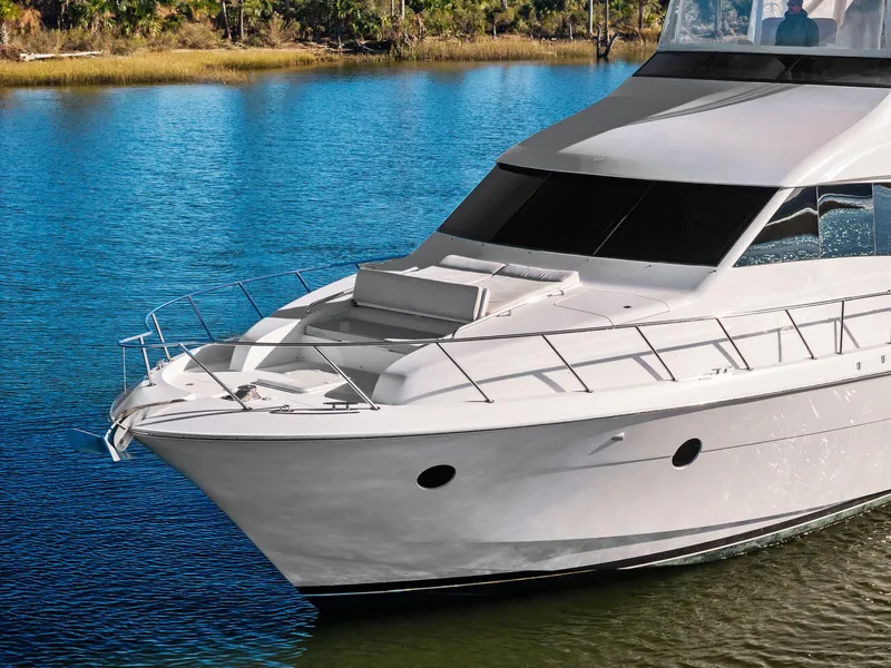 Slide: The Image of 2016 Hatteras M60 yacht deck with sun loungers on calm water. - 6