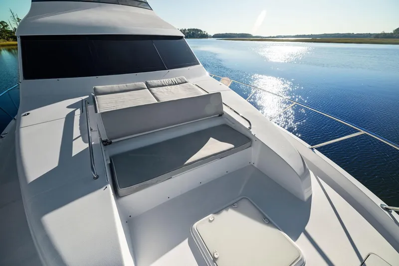 Slide: The Image of Luxurious 2016 Hatteras M60 yacht deck with seating and staircase, overlooking serene waters. - 7