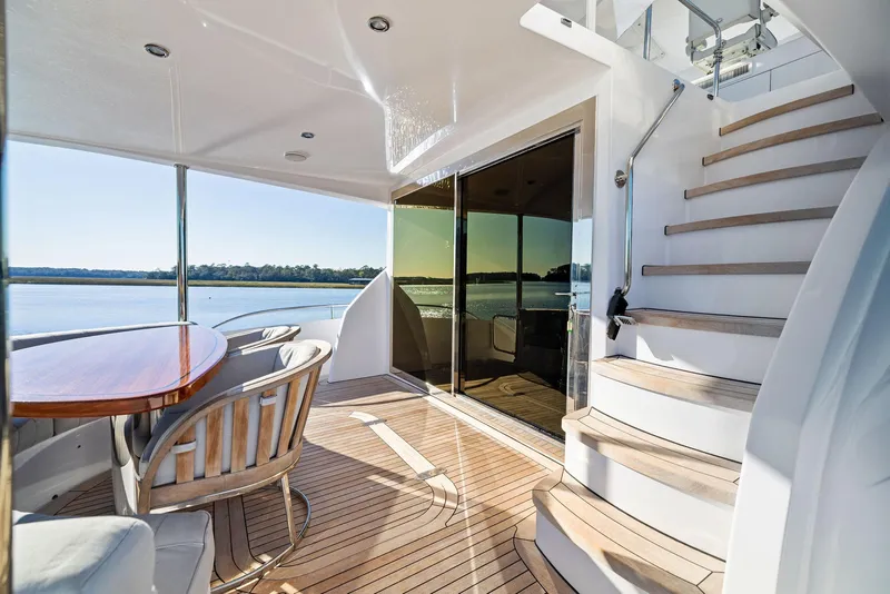 Slide: The Image of Luxurious 2016 Hatteras M60 yacht deck with seating, table, and scenic water view. - 8