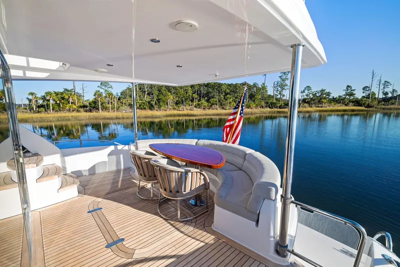 Slide: The Image of Luxury 2016 Hatteras M60 yacht deck with elegant seating and scenic water view. - 9