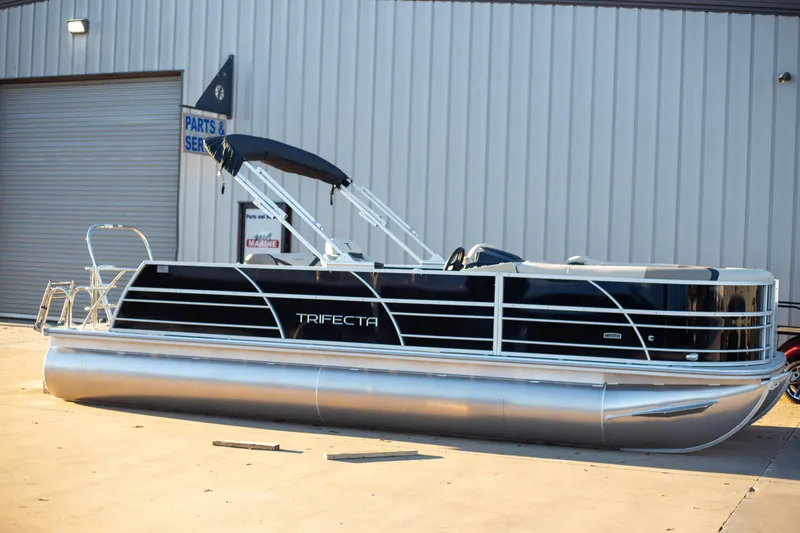 Slide: The Image of 2025 Trifecta 24UL CS pontoon boat parked outside service center. - 6