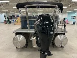 Slide: The Image of 2024 Crest Classic DLX 200 pontoon boat with powerful outboard motor in showroom. - 7