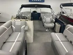 Slide: The Image of 2024 Crest Classic DLX 200 pontoon boat interior with gray seating and helm. - 8