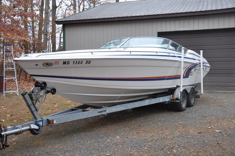 Slide: The Image of 2006 Formula 271 FASTech boat on trailer, parked near a garage. - 2