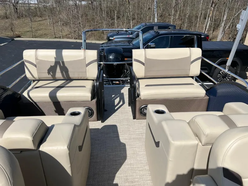 Slide: The Image of 2024 Crest Classic LX 220 pontoon boat with beige seating and spacious deck layout. - 10