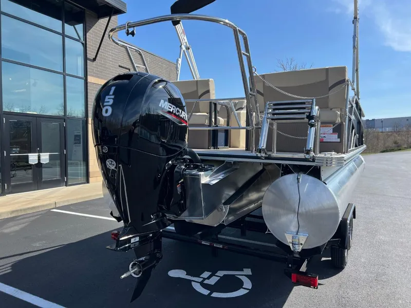 Slide: The Image of 2024 Crest Classic LX 220 pontoon boat with Mercury 150 engine in parking lot. - 4