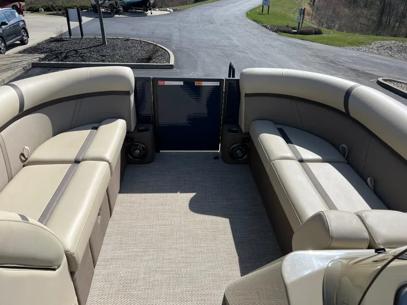 Slide: The Image of 2024 Crest Classic LX 220 boat interior with beige seating and spacious layout. - 6