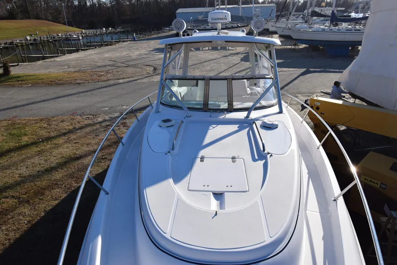 Slide: The Image of 2005 Donzi 38 ZSF boat docked, featuring a sleek white deck and Garmin equipment. - 16
