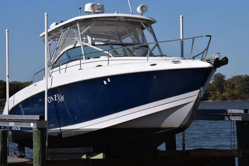 Slide: The Image of 2005 Donzi 38 ZSF boat docked by the water on a sunny day. - 2