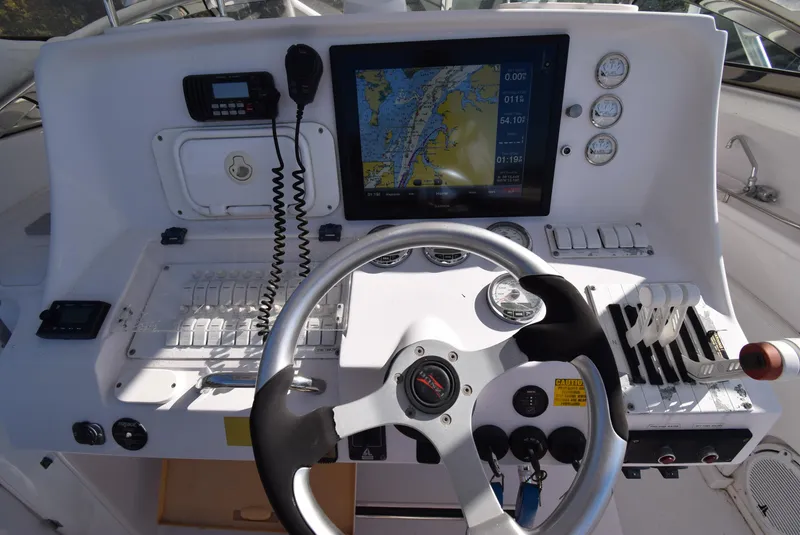 Slide: The Image of Control panel of a 2005 Donzi 38 ZSF boat with navigation screen and steering wheel. - 25