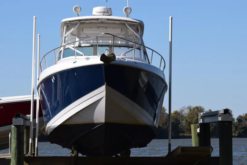 Slide: The Image of 2005 Donzi 38 ZSF boat docked, front view, with clear blue sky background. - 3